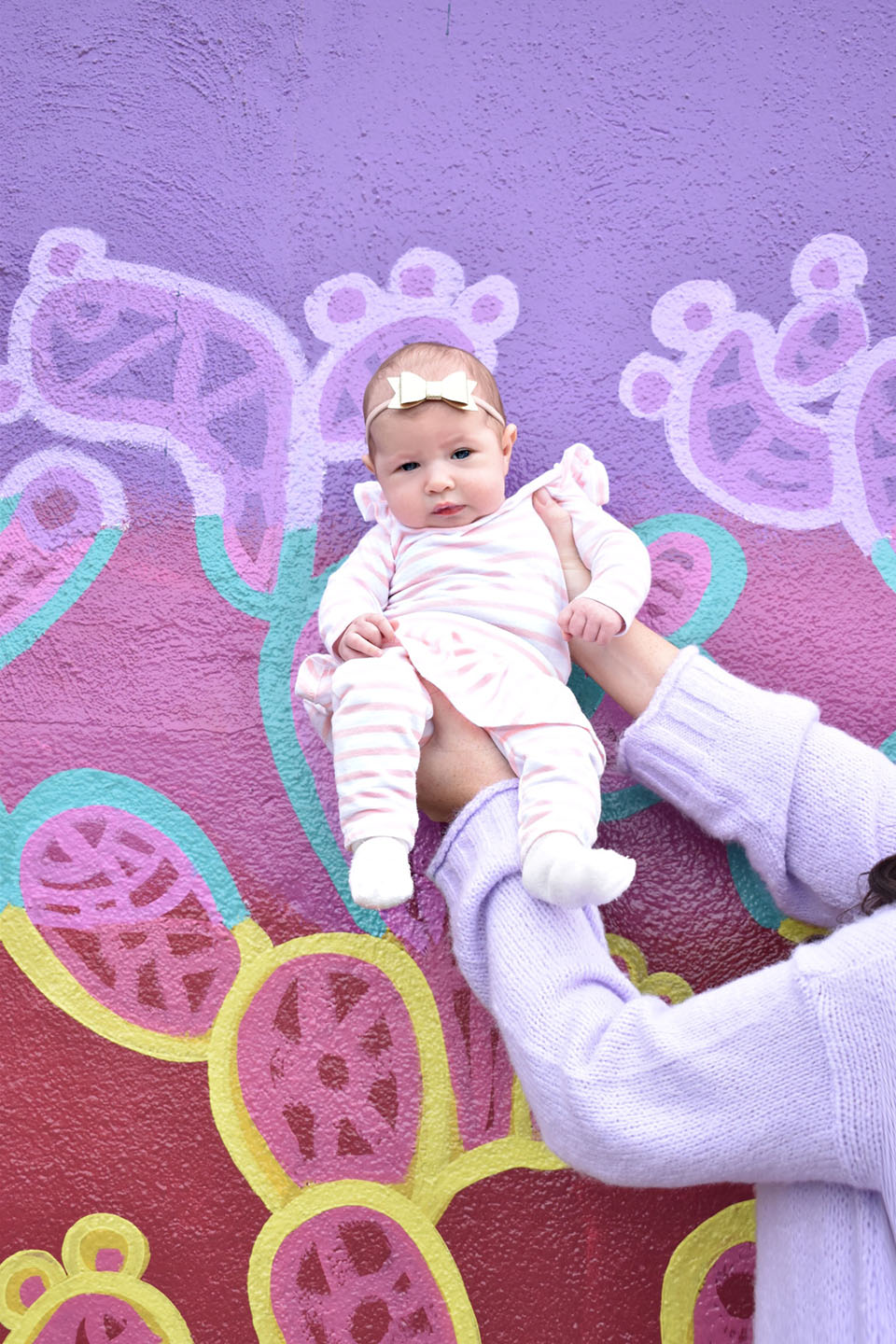 Collins Eliza wearing Rosie Pope baby at a Tallahassee street art wall.